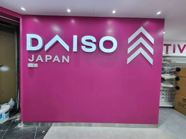 White Daiso Japan lettering installed on a magenta retail feature wall